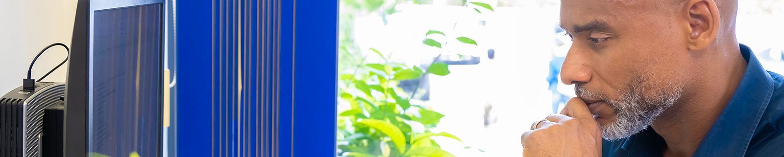 Een man die aandachtig naar een computerscherm kijkt